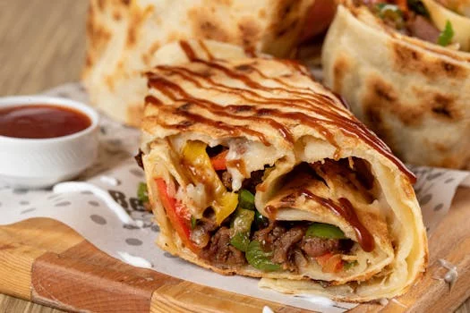 steak burrito with grilled peppers onions